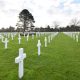 Photograph of a large military cemetary with rows of white crosses