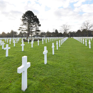 Photograph of a large military cemetary with rows of white crosses