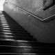 black and white photo of darkened subway stairs leading up to the light