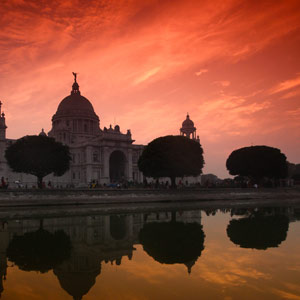 A photo of Victoria Memorial in Calcutta, India reflected in the water at sunset