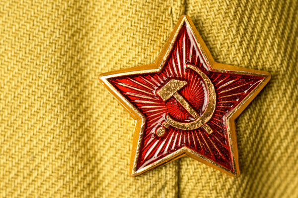 Old soviet military badge with hammer and sickle on light green cloth
